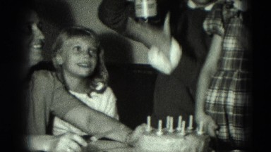 1951: mother holding knife getting ready to cut birthday cake