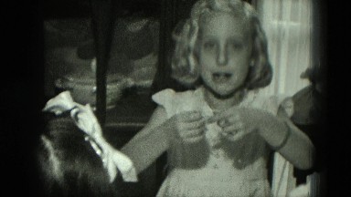 1951: birthday girl opens presents and examines them with onlookers present