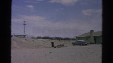 1966: view of several houses in desert neighborhood with mountains