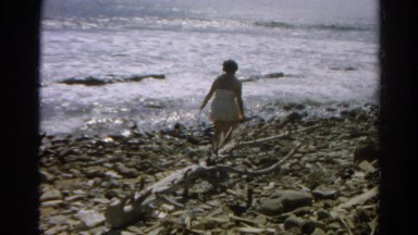1966: vacationing sunbathers search for shells on rocky sea shore CALIFORNIA