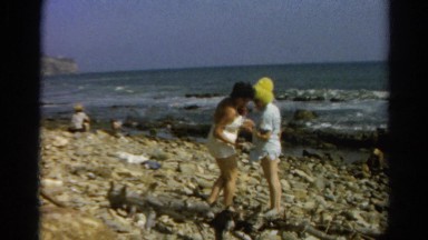 1966: family in swimsuits and funny hats at rocky beach area CALIFORNIA