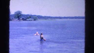1966: father and mother and two female children throwing red ball in lake