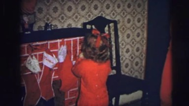 1974: girl puts her christmas sock above the fireplace LYNBROOK, NEW YORK