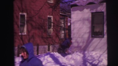 1974: children playing in snow and having snowball fight in yard, getting hit