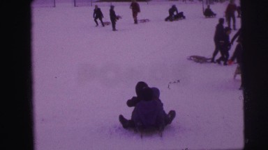 1974: kids sliding down the hill with winter stuff LYNBROOK, NEW YORK