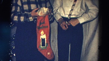 1968: brothers holding christmas stockings and candy canes by xmas tree DILLER