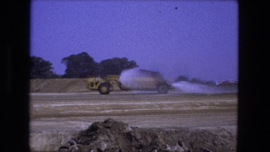 1976: bulldozer heavy industrial trucks spraying fields with water FORT WAYNE