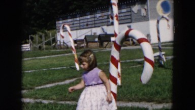 1957: little girls hugs and play around christmas stick. HICKSVILLE, NEW YORK