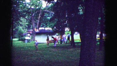 1971: pair lifts cardboard box for outing while children run ahead and others