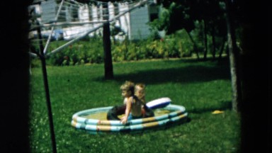 1957: two toddlers play in small inflatable swimming pool HICKSVILLE, NEW YORK