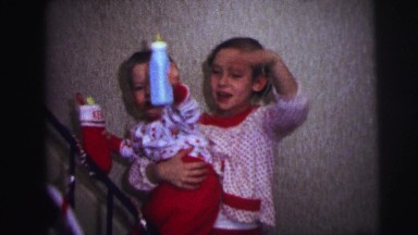 1973: small children waving while walking up stairway during christmas LYNBROOK