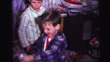 1973: children opening christmas gifts while in pajamas LYNBROOK, NEW YORK