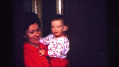 1973: smiling baby being held by mother inside home. LYNBROOK, NEW YORK