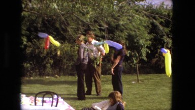 1974: family members relax at an outdoor birthday party decorated with balloons