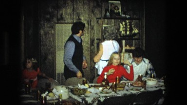 1974: family gathering at table, while grandmother reaches up on high shelf