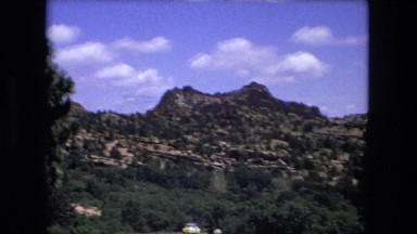 1974: beautiful blue sky above beautiful rugged mountain peak as seen pine trees