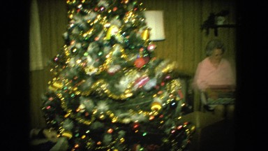 1974: man and woman open presents in front of christmas tree FORT WAYNE, INDIANA