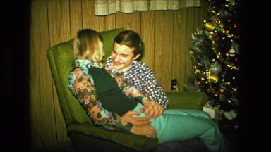 1974: couple is sitting next to christmas tree FORT WAYNE, INDIANA