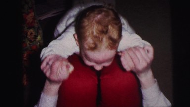 1973: mother is playing with her child keeping on her knees LYNBROOK, NEW YORK