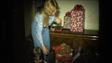 1974: young girl and an older girl opening christmas gifts FORT WAYNE, INDIANA