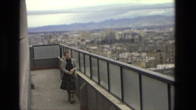 1978: young girl wearing plaid skirt walking across bridge