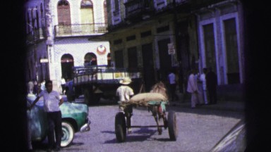 1967: on an town road cart riding middle of the street while jeep over taking it