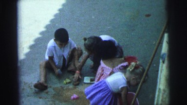 1967: kids playing together with buckets and shovels in the sand having fun.