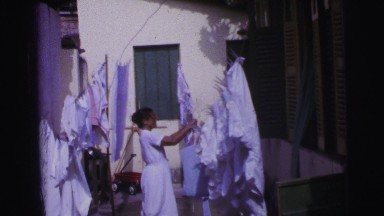 1967: african american women doing laundry outside clothesline hanging sheets