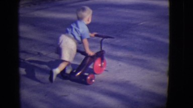 1946: little boy riding his bike on the street DETROIT, MICHIGAN