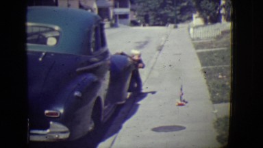 1946: cute blonde kid appears from side of car DETROIT, MICHIGAN