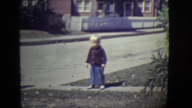 1946: small boy standing alone in road side,goes behind lady. DETROIT, MICHIGAN