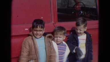 1967: cute multicultural kids by old red pickup truck outdoors LINCOLN, NEBRASKA