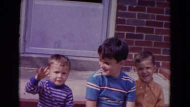 1967: brothers waving at camera on the patio. LINCOLN, NEBRASKA