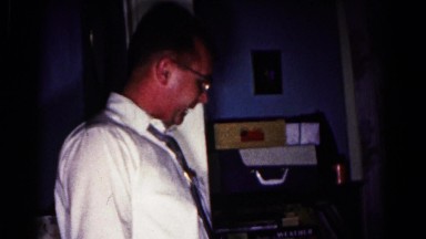 1962: two men in blue room looking at child teaching baby to dance HAGERSTOWN