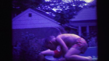1972: brother and sister playing happily in backyard pool in the summer