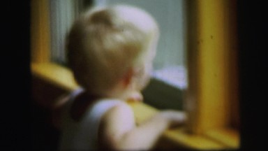1972: little boy looking out the window LYNBROOK, NEW YORK