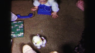 1972: twin babies crawling around on the floor playing with toys on christmas