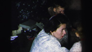 1972: mother playing with children in pajamas xmas morning gift opening