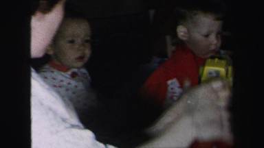 1972: two brothers sitting on the floor watching gifts being opened
