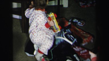 1972: children in pajamas examining their christmas gifts under the tree