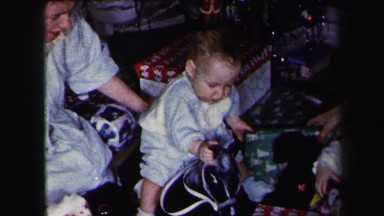 1972: twin babies crawling around on the floor playing with toys on christmas