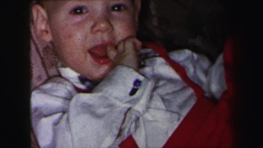 1972: baby in white shirt and red pants playing with his foot LYNBROOK, NEW YORK