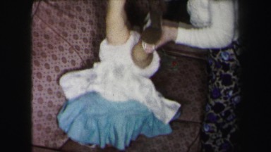 1972: mother playing with her baby daughter on the sofa LYNBROOK, NEW YORK