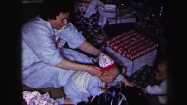 1972: parents putting matching stocking caps on kids xmas tree patterned