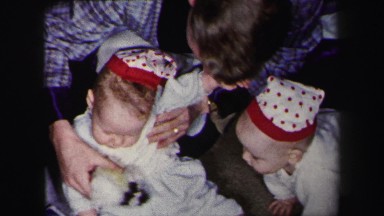1972: twin babies crawling around on the floor playing with toys on christmas