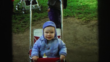 1972: bouncy baby rides in stroller on grassy ground LYNBROOK, NEW YORK