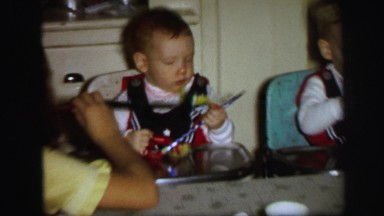 1972: high chair babies at their birthday party with mom off to the side