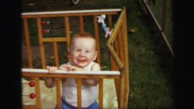 1972: baby playing in wood crib happy redhead caucasian child LYNBROOK, NEW YORK
