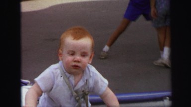 1972: happy baby in stroller with other kids pushing another stroller nearby