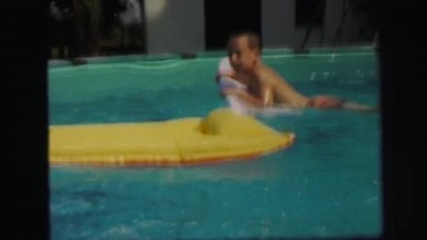 1972: two boys and girl play happily in backyard pool with float toys
